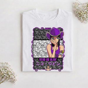 May include: White t-shirt featuring a graphic of a woman in a purple hat and outfit. The design includes the text "WANTED" and "DEAD OR ALIVE" in English and Japanese, along with a skull pattern.