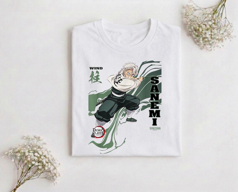 Puede incluir: Camiseta blanca con un gr&aacute;fico de un personaje de anime con cabello blanco, empu&ntilde;ando una espada. El dise&ntilde;o incluye el texto "WIND" en negro, caracteres japoneses y el nombre "SANEMI" en letras negras verticales. La camiseta tambi&eacute;n tiene el logo de "Demon Slayer".