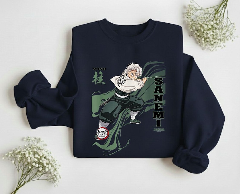 Puede incluir: Sudadera azul marino con un gr&aacute;fico de un personaje de la serie de anime Demon Slayer. El personaje se representa en una pose din&aacute;mica con una capa verde, y el nombre "SANEMI" est&aacute; impreso verticalmente. La palabra "WIND" tambi&eacute;n es visible.