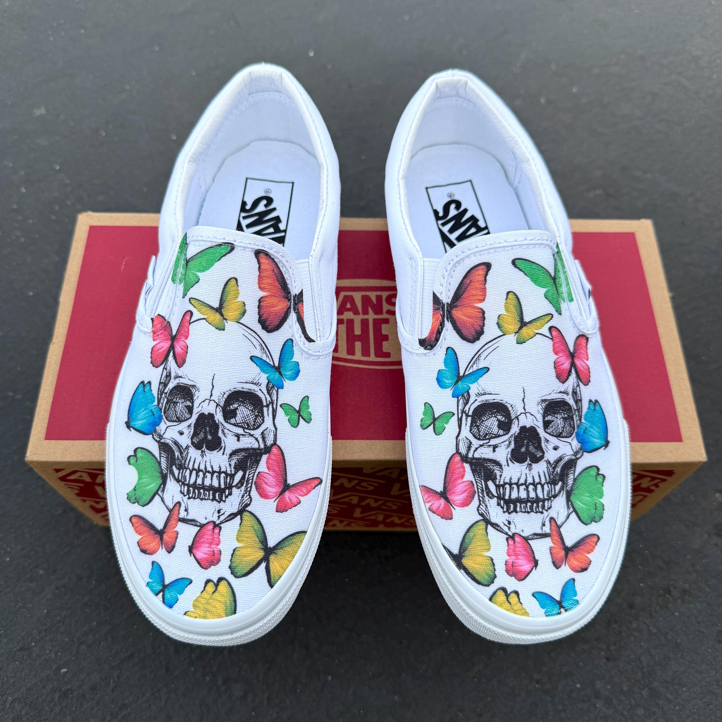蝶が描かれたスカル柄の Vans スリッポン シューズ - 女性と男性向けの 