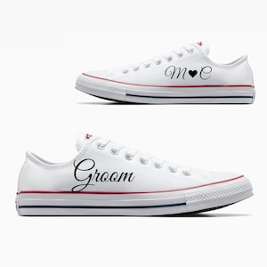 May include: A pair of white canvas sneakers with black text. One shoe says "Groom" and the other says "M♥E".