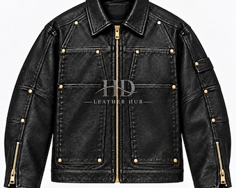 Könnte beinhalten: Eine schwarze Lederjacke mit goldenem Frontreißverschluss, goldenen Metallnieten entlang der Nähte und Reißverschlüssen an den Ärmelbündchen. Auf der Brust steht der Text HD LEATHER HUB in weißer Schrift. Jacke mit klassischem Kragen und langen Ärmeln.