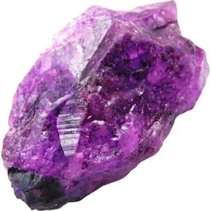 May include: A raw, uncut amethyst crystal with a deep purple hue. The gemstone has a rough, textured surface with visible crystalline structures and varying shades of purple, from light to dark. The overall shape is irregular and natural.