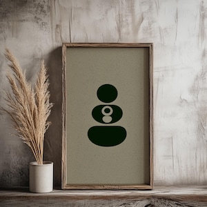 May include: A framed art print featuring a dark green abstract design of stacked oval and circular shapes on a beige background. The artwork is displayed on a wooden shelf next to a vase of dried ornamental grass.