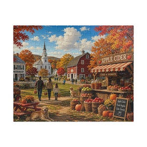 May include: A jigsaw puzzle depicting a rural autumn scene with a white church, a red barn, and an apple cider stand. The stand features a striped awning, crates of apples, and a chalkboard sign reading Fresh Apples Cider Donuts.