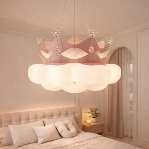 May include: A pink crown-shaped chandelier with crystal accents hangs above a bed. The light fixture has a cloud-like bottom and is suspended from the ceiling. The bedroom has a neutral color palette.