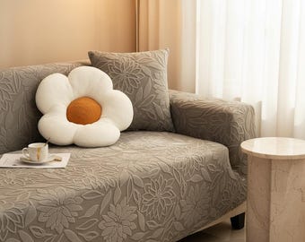 Funda elástica antideslizante para sofá con estampado jacquard de camelia.