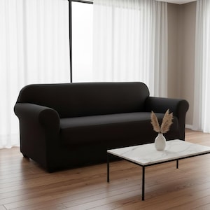 May include: A white ceramic mug with a black handle and the text "But First, Coffee" in a black, handwritten-style font. The mug is on a white surface.