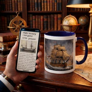 Pode incluir: Uma caneca de cerâmica branca com interior e alça azuis, apresentando uma ilustração detalhada de um navio alto no mar. A imagem é definida contra um céu tempestuoso. Um smartphone exibe informações sobre o HMS Victory.