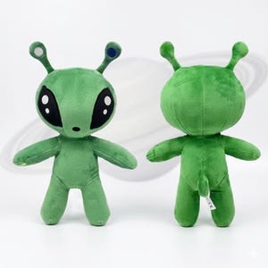 May include: Two green plush alien toys. One alien faces forward with large black eyes, small nose, and two antennae with white and blue tips. The other alien is facing backward. Both have small arms and legs.