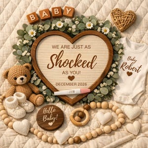 Può includere: Annuncio di un bambino su una superficie color crema. L'annuncio include una cornice di legno a forma di cuore con il testo "WE ARE JUST AS SHOCKED AS YOU!" e "DECEMBER 2026". Altri elementi includono un orsacchiotto, scarpine e un body.