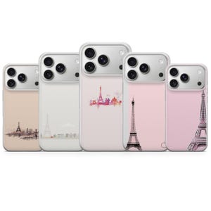 Op de afbeelding: Vijf telefoonhoesjes met Eiffeltoren-ontwerpen. De hoesjes hebben verschillende kleurenschema's, waaronder beige, wit en roze, met illustraties van het iconische monument. De ontwerpen variëren van gedetailleerde schetsen tot aquarelstadsgezichten.