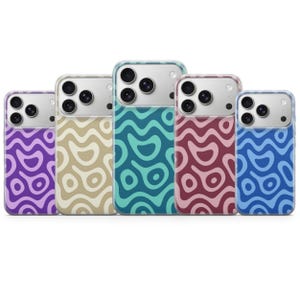 Peut inclure: Cinq coques de smartphone alignées, chacune présentant un motif organique ondulé bicolore distinct. Les coques sont de couleur violette, beige, sarcelle, bordeaux et bleue, et présentent toutes une découpe pour triple objectif photo au dos.