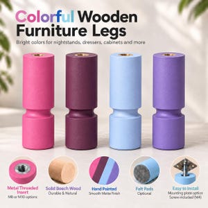 Può includere: Quattro gambe per mobili cilindriche in legno nei colori rosa, viola scuro, azzurro e lavanda. Il testo recita Colorful Wooden Furniture Legs. Presentano un inserto filettato in metallo, legno di faggio massiccio e feltrini.