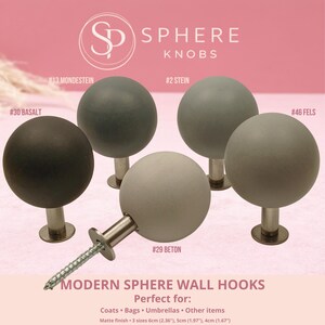 Pode incluir: Ganchos de parede esféricos em vários tons de cinza e preto, com acabamento fosco. A imagem mostra cinco ganchos com hastes e parafusos de metal. O texto diz "Sphere Knobs" e "Modern Sphere Wall Hooks."