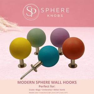 Puede incluir: Un conjunto de ganchos de pared esféricos modernos en varios colores: amarillo, verde, morado, naranja y turquesa. Cada gancho tiene una base metálica y una cabeza esférica. El texto dice "SPHERE KNOBS" y "MODERN SPHERE WALL HOOKS".