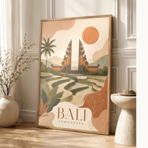 Peut inclure: Une impression d'art mural rectangulaire dans un cadre en bois clair représentant une illustration stylisée de Bali, en Indonésie. L'œuvre montre une porte traditionnelle fendue, des rizières en terrasses, un palmier et un grand soleil orange, avec le texte BALI INDONESIA.