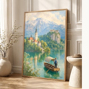 Può includere: Un dipinto paesaggistico incorniciato raffigurante un lago con una piccola barca in legno che trasporta una persona sotto una tettoia. Sullo sfondo, una chiesa con un alto campanile e un castello su una scogliera, con montagne innevate.