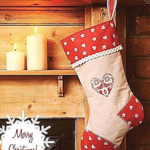 May include: A white Christmas stocking with red and white fabric accents. The stocking has a red heart with a bird design and the words "Merry Christmas!" are written on a white snowflake.