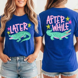 May include: Blue t-shirts with a graphic of a green alligator and the text "LATER" on the front and "AFTER WHILE" on the back. The text is in pink with yellow and pink star accents.
