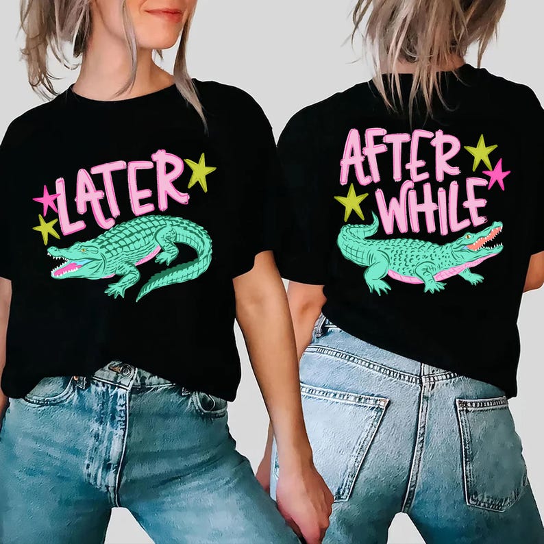 May include: Black t-shirts with a teal alligator graphic. One shirt says "LATER" in pink with yellow stars, and the other says "AFTER WHILE" in pink with yellow and pink stars. The shirts are paired with blue jeans.