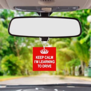 May include: Red car air freshener with a white crown and the text "Keep Calm I'm Learning To Drive".