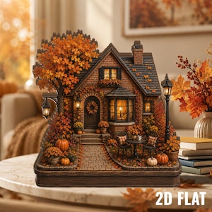 Könnte beinhalten: Eine Miniatur-Backsteinhaus-Figur im Herbst-Design mit orangefarbenen Ahornbäumen, Kürbissen und einem Kopfsteinpflasterweg. Das Modell umfasst eine Eingangstür mit Kranz, ein Erkerfenster, einen Schornstein und zwei schwarze Straßenlaternen.