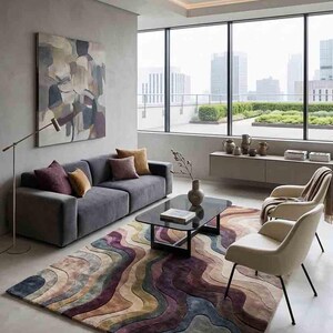 Puede incluir: Un salón moderno con un sofá gris, dos sillas color crema y una mesa de centro negra. Una alfombra colorida con un patrón ondulado en tonos morados, azules y beige cubre el suelo. Una gran ventana ofrece vistas a la ciudad.