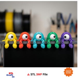 May include: Five articulated figurines in yellow, red, light blue, green, and purple, each featuring a single large white eye with a black pupil. These creatures have jointed limbs and are positioned along the edge of a flat surface.