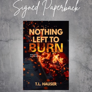 May include: A signed paperback book titled "Nothing Left to Burn" by T.L. Hauser. The book cover features a fiery image of burning embers with the title in bold orange letters. The words "Signed Paperback" are written in cursive.