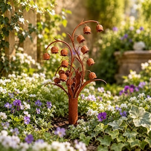 May include: A rust-colored metal garden stake featuring a cluster of bell-shaped flowers on thin, curved stems. The sculpture has a weathered, oxidized finish and is designed to be inserted into the ground, showcasing multiple hanging blossoms.