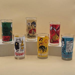 May include: A set of six clear glass tumblers, each featuring a unique colorful graphic design representing different locations: Italy, Japan, England, Hawaii, Spain, and France. Each glass displays iconic landmarks or cultural figures with the name of the region printed in bold, stylized lettering.