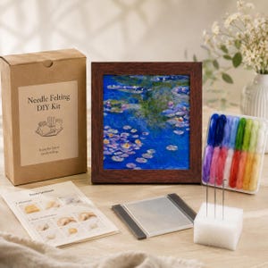 Peut inclure: Un kit de bricolage de feutrage à l'aiguille comprenant une boîte en carton marron étiquetée Needle Felting DIY Kit, une œuvre d'art encadrée représentant un étang de nénuphars bleu, un plateau de laine cardée colorée, trois aiguilles et des instructions.