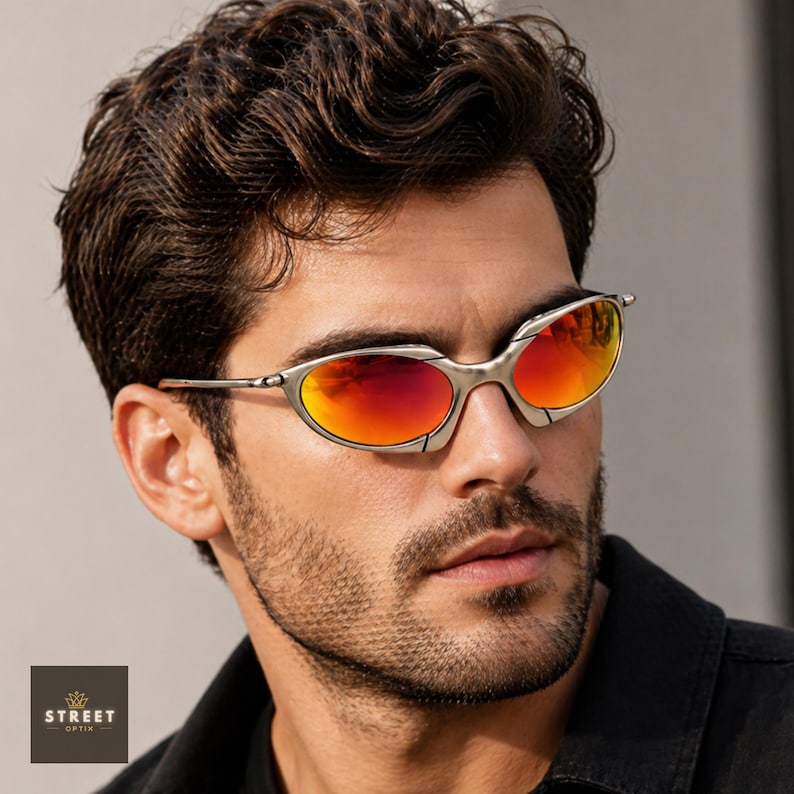 Peut inclure: Lunettes de soleil &agrave; monture argent&eacute;e avec verres rouges et oranges. Les lunettes de soleil ont un design &eacute;l&eacute;gant et moderne. L'image comprend &eacute;galement le logo Street Optix en bas &agrave; gauche.