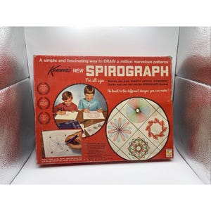 May include: A vintage Kenner Spirograph box with a red background. The box features the text "NEW SPIROGRAPH" and illustrations of children using the toy. The box also shows examples of the patterns that can be created.
