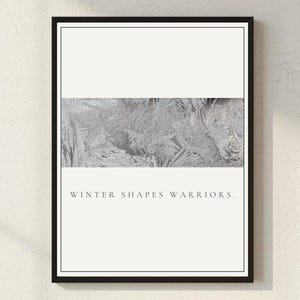 Op de afbeelding: Ingelijste kunstdruk met een zwarte rand. Het kunstwerk toont een gestructureerd, grijs, abstract ontwerp in het midden, met een witte boven- en onderkant. De tekst "WINTER SHAPES WARRIORS" is onderaan in een schreefletter gedrukt.