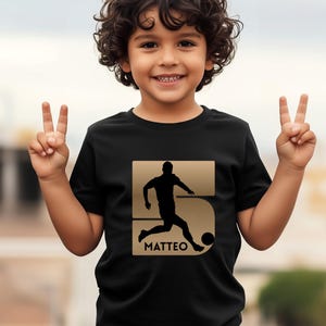 Kind trägt schwarzes personalisiertes Fußball T-Shirt mit Name und Nummer, Geschenk für fußballbegeisterte Jungen