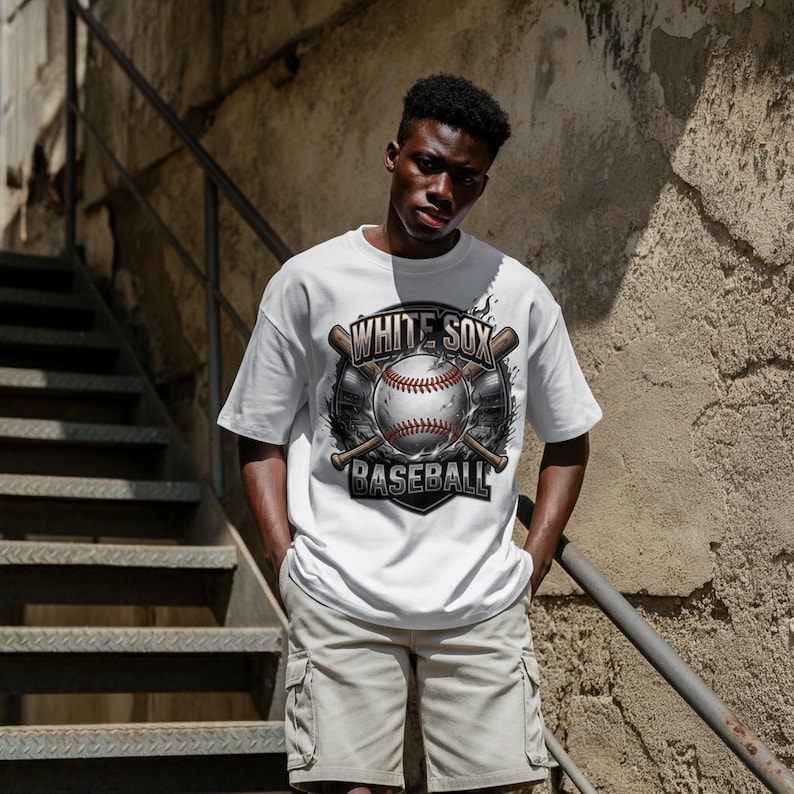 Op de afbeelding: Wit T-shirt met een honkbalafbeelding met de tekst "WHITE SOX BASEBALL". Het ontwerp bevat een honkbal en gekruiste knuppels. Het shirt wordt gecombineerd met kaki cargoshorts.