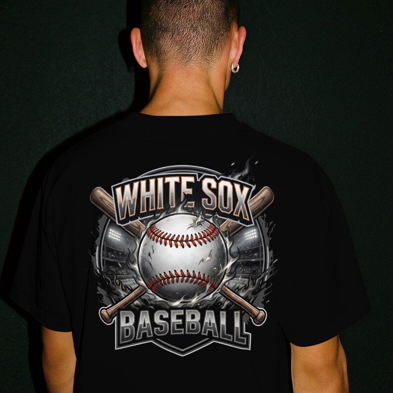 Op de afbeelding: Zwart T-shirt met een honkbalontwerp. Het ontwerp bevat een honkbal, gekruiste knuppels en de woorden "WHITE SOX BASEBALL" in een gestileerd lettertype. De afbeelding heeft een donkere achtergrond.