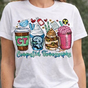 May include: White t-shirt featuring a colorful graphic of four stylized coffee drinks, each representing a different aspect of Computed Tomography (CT) scans. The design includes medical symbols, a brain, and the words "Computed Tomography".