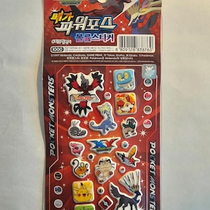 Puede incluir: Una hoja de pegatinas Pokémon coloridas con varios personajes y el texto "POCKET MONSTERS". Las pegatinas están sobre un fondo rojo y negro con texto coreano y un código de barras.