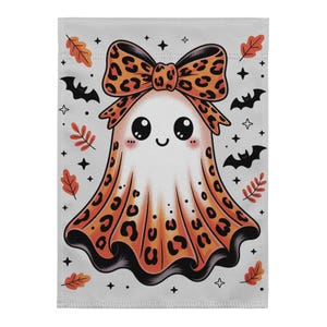 Peut inclure: Un drapeau de jardin rectangulaire représentant un fantôme blanc avec un grand nœud à motif léopard orange et noir sur la tête. Le fantôme présente un motif léopard assorti en bas, des yeux noirs et un sourire. Des feuilles orange, des chauves-souris noires et des étoiles l'entourent.