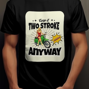 Könnte beinhalten: Schwarzes T-Shirt mit einem Retro-Grafikmotiv einer Frau auf einem grünen Roller. Der Text lautet "Keep it Two Stroke Anyway" mit einer gelben Sprechblase mit "Schwalbe".