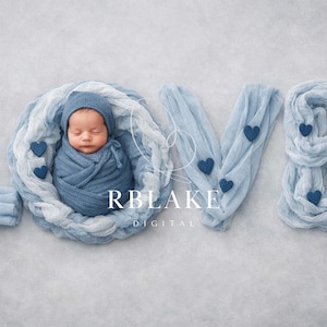 May include: A newborn baby wrapped in a blue swaddle and hat, nestled within a soft, light blue fabric arrangement spelling out the word "LOVE". Dark blue heart accents are scattered throughout the design.
