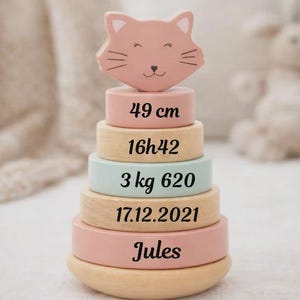 Op de afbeelding: Een set van drie keramische mokken met een gespikkelde, matte afwerking. De mokken zijn in crème, lichtgrijs en donkergrijs. Elke mok heeft een eenvoudig, minimalistisch ontwerp.