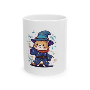 Op de afbeelding: Witte keramische mok met een cartoonkat verkleed als tovenaar. De kat draagt een blauwe tovenaars hoed en gewaad met sterren, een rode sjaal en een riem. Het ontwerp bevat kleurrijke sterren en glitters.