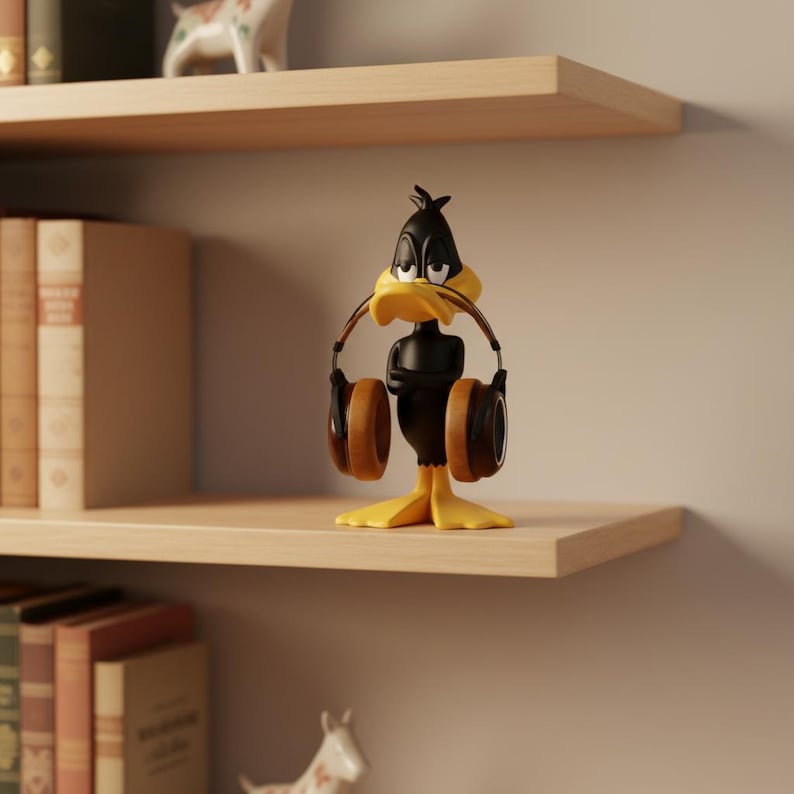 May include: A Daffy Duck figurine with headphones. The black and yellow cartoon character is standing on a wooden shelf, holding brown headphones. The figurine is a collectible item, perfect for fans of Looney Tunes.