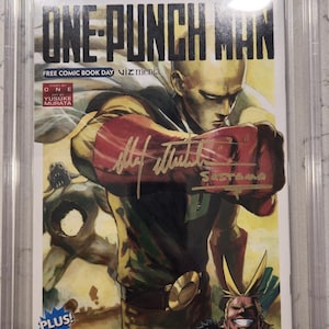May include: A graded comic book featuring the cover art of "One-Punch Man" and "My Hero Academia." The cover art includes a character with a bald head and a red and yellow costume. The comic is encased in a protective plastic case with a 9.8 grade.