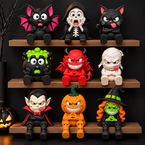 May include: A collection of nine small Halloween-themed figurines arranged on three wooden shelves. The figures include a black bat, a skeleton in a hooded cloak, a black cat, a black cauldron with green slime, a red devil, a white mummy, a vampire, a pumpkin, and a witch with orange hair.