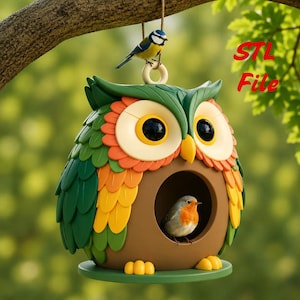 May include: A hanging birdhouse shaped like an owl with green, orange, and yellow feathers, large yellow eyes, and a circular entrance. A small blue bird sits on top, and a robin is inside the opening. The text STL File is visible.